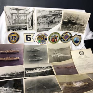 May include: A collection of vintage naval memorabilia, including black and white photographs of ships at sea, along with several embroidered patches. The patches feature text such as "U.S.S. Truckee A.O.-147" and "Service Force Sixth Fleet".