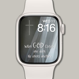 Op de afbeelding: Een witte Apple Watch met een witte band waarop een citaat staat: "Wanneer God een deur sluit, opent Hij er een andere." De tijd is 8:16 en de datum is wo 11.