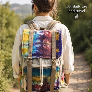 Könnte beinhalten: Ein farbenfroher Rucksack mit Batikmuster, braunen Trägern und Kordelzugverschluss. Der Rucksack hat eine Vordertasche mit Reißverschluss und ist für den täglichen Gebrauch und Reisen konzipiert.