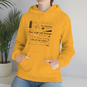 May include: A yellow hoodie with black text that reads "Dancing is Not a Crime", "The Overpass", "Dying in LA Say Amen (Saturday Night)", "Pray for the Wicked Old Fashioned", "(Fuck A) Silver Lining", "King of the Clouds One of the Drunks Roaring 205", "Hey Look Ma. I Made It".