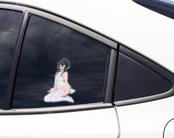 May include: A vinyl decal sticker applied to a car window featuring an anime-style character with dark hair and teal highlights, wearing a white sheer garment and white thigh-high stockings, posed in a kneeling position on a dark tinted surface.