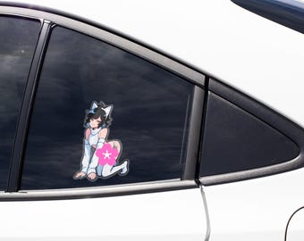 May include: A vinyl decal sticker applied to a car window featuring an anime-style character with black hair, cat ears, and a white sweater. The character is kneeling, and a bright pink cherry blossom flower icon covers the lower body area.