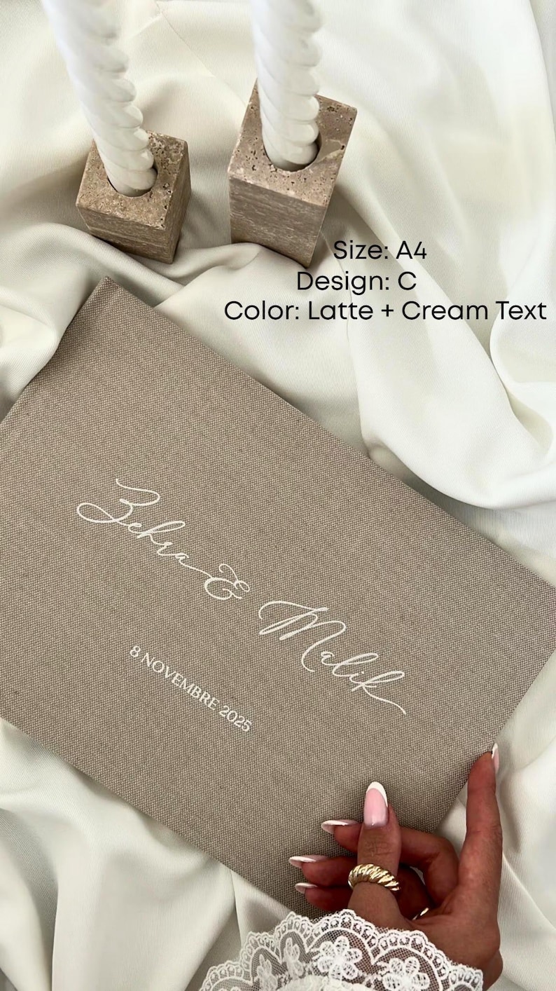 K&ouml;nnte beinhalten: Ein beiges Buch im A4-Format mit cremefarbenem Text, das die Namen "Zehra & Malik" und das Datum "8 NOVEMBRE 2025" tr&auml;gt. Das Design ist "C" mit einem Farbschema "Latte + Cream Text". Zwei quadratische Kerzenhalter mit wei&szlig;en Kerzen im Hintergrund.