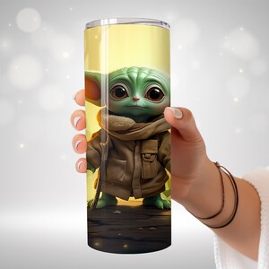 May include: A stainless steel tumbler with a green and brown image of a character from the Star Wars franchise. The character is wearing a brown coat and has large ears.