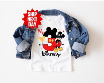 May include: White t-shirt with a red number 3 and a cartoon image of Mickey Mouse wearing sunglasses. The text "My 3rd Birthday" is printed below the image.