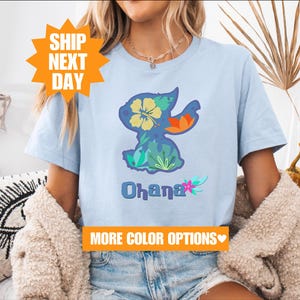 a woman sitting on a couch wearing a t - shirt with an image of a