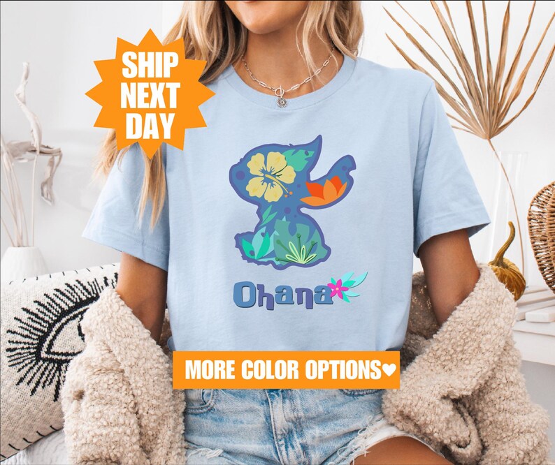 a woman sitting on a couch wearing a t - shirt with an image of a