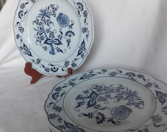 May include: A set of six white dinner plates with a blue and white floral pattern. The plates have a scalloped edge and are made of porcelain.