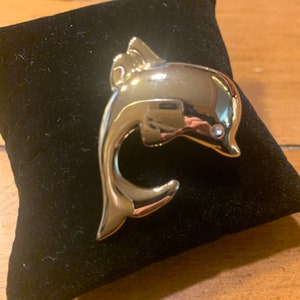 Gold tone dolphin pin with rhinestone eye