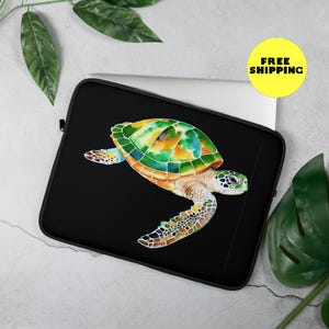 May include: Black laptop sleeve featuring a colourful sea turtle illustration. The turtle has a green shell with yellow and orange accents. The background is black.