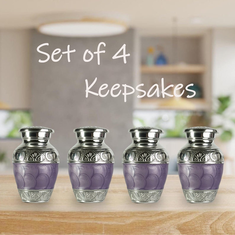 May include: Set of 4 keepsakes. Four decorative urns with silver-colored lids and bases, and a lavender-colored body with a textured pattern. The text "Set of 4 Keepsakes" is written in white script above the urns.