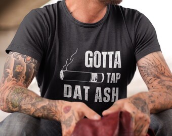 May include: A black t-shirt with a white graphic of a cigarette with the text "Gotta Tap Dat Ash".