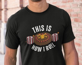 Può includere: Una maglietta nera con una grafica bianca di una roulette e fiches da poker. Il testo "This is how I roll" è stampato sotto la grafica.
