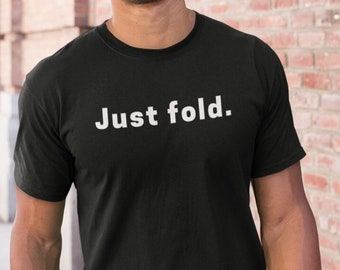 Può includere: Un uomo indossa una maglietta nera con la scritta "Just fold." stampata in bianco. Sta sorridendo e camminando su un marciapiede.