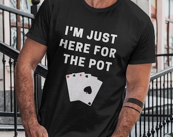 Può includere: Una maglietta nera con la scritta "I'm just here for the pot" e una grafica di quattro carte da gioco. La persona che indossa la maglietta è in piedi su una rampa di scale.