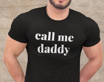May include: A black t-shirt with the text "call me daddy" printed in white.