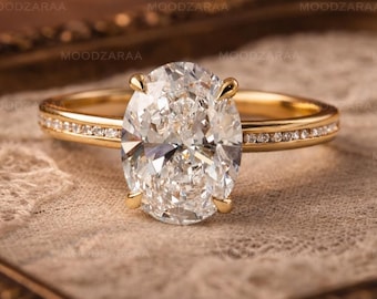 May include: A gold engagement ring with a large oval-cut diamond center stone. The band is also adorned with smaller diamonds. The ring is displayed on a lace-like fabric within a decorative gold frame.