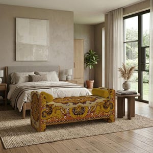 May include: A rectangular upholstered bench featuring a vibrant, intricate floral and paisley pattern in shades of mustard yellow, burnt orange, and brown, with two matching cylindrical bolster pillows at each end of the seat.