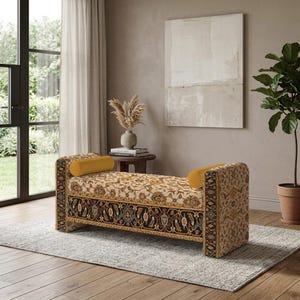 May include: A rectangular upholstered bench featuring a cream-colored top with an intricate floral pattern and a black border with detailed botanical motifs. The bench includes two solid mustard yellow cylindrical bolster pillows at each end.