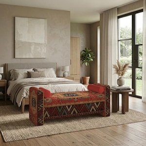 May include: A rectangular upholstered bench featuring a vibrant red, blue, and green geometric pattern with a central medallion design. The bench includes two cylindrical red bolster pillows at each end and stands on a woven textured rug.