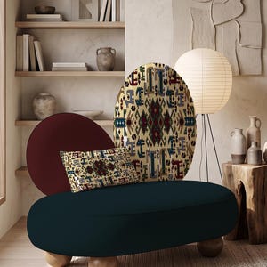 May include: A low-profile, dark navy blue upholstered bench with three rounded light wood feet. It features a circular maroon backrest and a large oval backrest with a cream, red, blue, and green geometric pattern, plus a matching rectangular cushion.