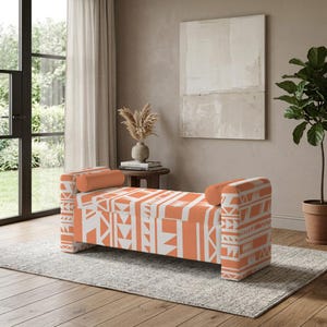 Puede incluir: Un banco de almacenamiento rectangular con un vibrante patrón geométrico en color naranja y blanco. El banco incluye dos cojines cilíndricos a juego en cada extremo, ofreciendo un aspecto estructurado con un asiento plano.