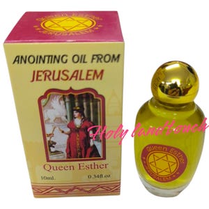 Puede incluir: Una pequeña botella de aceite de unción de Jerusalén, etiquetada como "Queen Esther" con una estrella de David. La botella es dorada y transparente, con un líquido amarillo en su interior. La etiqueta también dice "10ml. 0.34fl.oz."