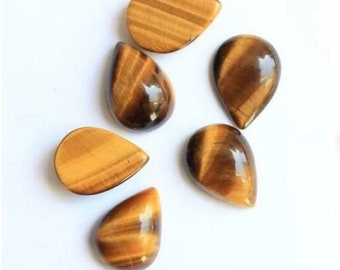 May include: Six teardrop-shaped tiger's eye cabochons in various shades of brown and gold. The stones are smooth and polished, with a chatoyant effect.