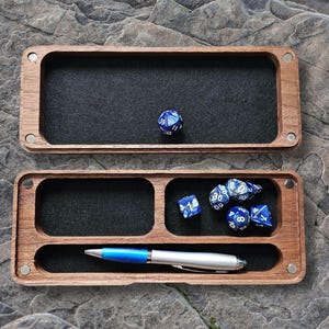 May include: A wooden box with a felt-lined interior and a separate compartment for dice and a pen. The box has a hinged lid and is ideal for storing and organising dice and other gaming accessories.