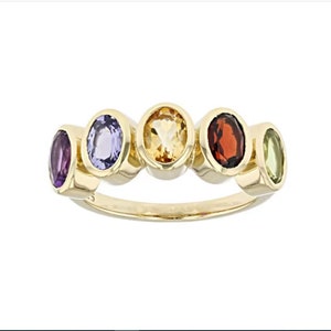 Könnte beinhalten: Ein goldener Ring mit fünf ovalen Edelsteinen. Die Edelsteine sind lila, blau, gelb, rot und grün.