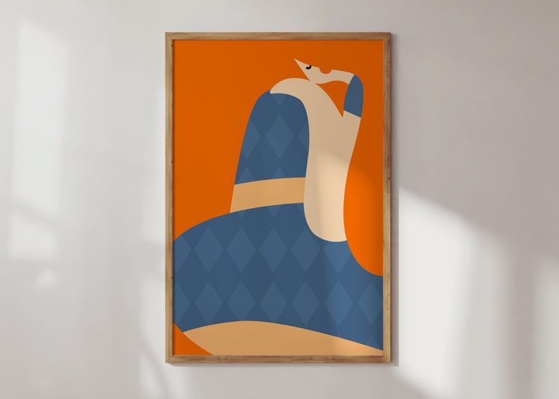 May include: Abstract art print with a figure in a blue diamond-patterned garment and a tan belt, set against an orange background. The artwork is framed in a natural wood frame, creating a modern aesthetic. The figure's arm is raised, adding a sense of movement.