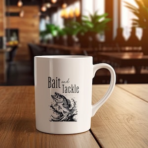 May include: White ceramic coffee mug with a black and white illustration of a fish jumping out of the water. The text "Bait and Tackle" is printed on the mug.