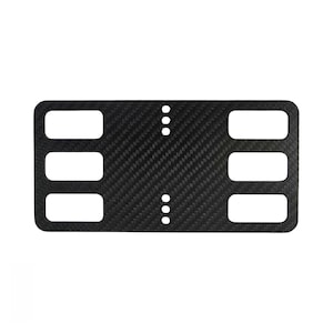 Puede incluir: Una placa rectangular de fibra de carbono con un patrón tejido negro. La placa tiene seis grandes recortes rectangulares horizontales dispuestos en dos columnas de tres, y dos filas verticales de tres pequeños orificios circulares en el centro.
