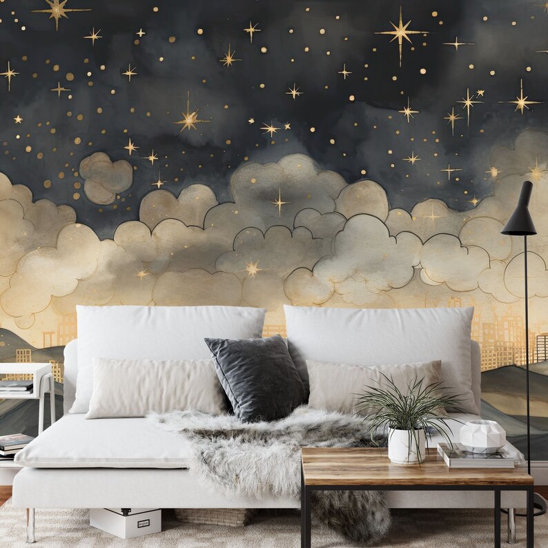 May include: A white couch with two pillows and a throw blanket, set against a dark blue and gold wallpaper featuring a night sky with clouds and stars.