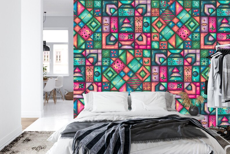 K&ouml;nnte beinhalten: Eine farbenfrohe geometrische Tapete in T&uuml;rkis-, Rosa-, Orange- und Gr&uuml;nt&ouml;nen ziert eine Schlafzimmerwand. Das Design zeigt Quadrate und Rechtecke mit verschiedenen Formen. Ein Bett mit wei&szlig;er Bettw&auml;sche und einer grauen Decke befindet sich vor der Wand.