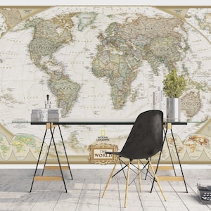 Könnte beinhalten: Eine detaillierte Weltkarte im Vintage-Stil bedeckt eine Wand, mit einem Schreibtisch und einem Stuhl davor. Die Karte zeigt geografische Details und Text. Ein schwarzer Stuhl mit Holzbeinen steht in der Nähe des Schreibtischs. Die Worte "THE WORLD" sind sichtbar.