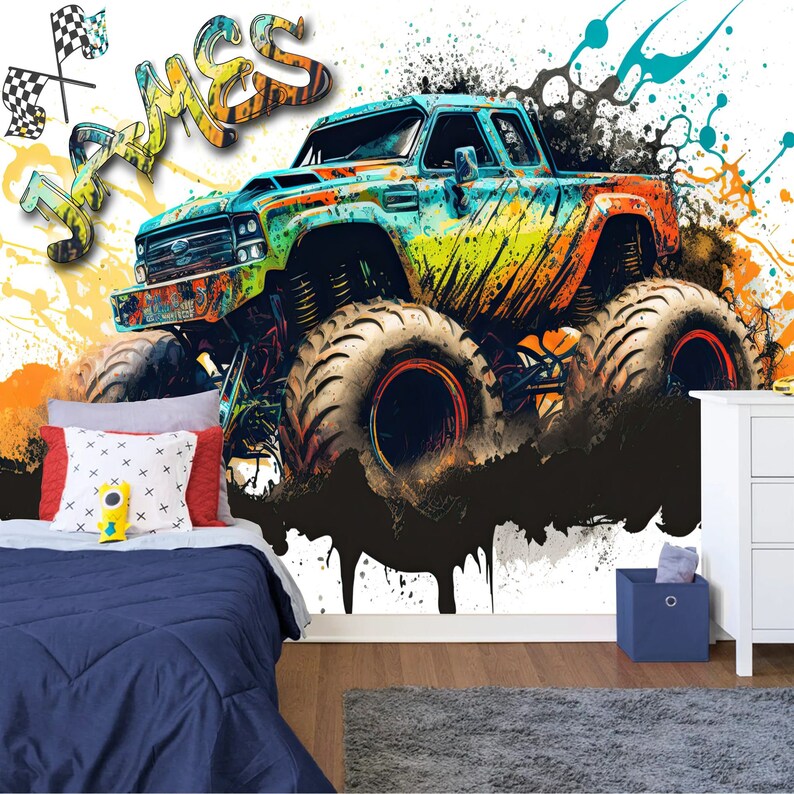 May include: A colorful monster truck with the name "James" painted on the wall behind it. The truck is on a white background with black and orange splatters of paint.