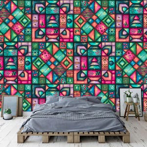 May include: A colorful, geometric wallpaper with a patchwork design. The pattern features squares and rectangles in shades of teal, pink, orange, and green. The wallpaper is installed behind a bed with gray bedding and a wooden pallet frame.