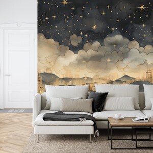May include: A white sectional sofa with a black throw blanket sits in front of a wall mural depicting a city skyline at night with gold stars and clouds.