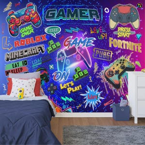 May include: A bedroom wall mural with a gaming theme. The design includes the word "GAMER", game controllers, and game titles like "Minecraft" and "Fortnite". The colour scheme is a mix of blues, purples, and pinks. The mural also features the words "Game Over" and "Let's Play!"
