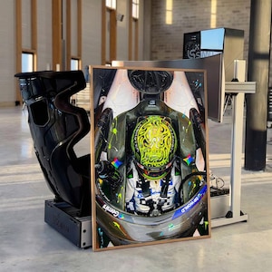 Könnte beinhalten: Ein gerahmter vertikaler Druck, der einen Formel-1-Fahrer im Cockpit zeigt, mit einem leuchtend gelben Helm mit schwarzen Mustern und einem weißen Rennanzug. Das Bild enthält lebhafte Farbspritzer sowie den Text Gemini und DP World.