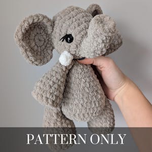 May include: A crocheted gray elephant plush toy with large ears, black eyes, and a white pom-pom. The elephant is made of a soft, textured yarn. The text "PATTERN ONLY" is displayed at the bottom of the image.
