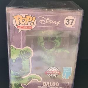 Puede incluir: Una figura de vinilo de Baloo de la serie Disney Pop! Art, número 37, en una funda protectora. La figura es verde con un diseño floral. El embalaje incluye el sello "Special Edition".