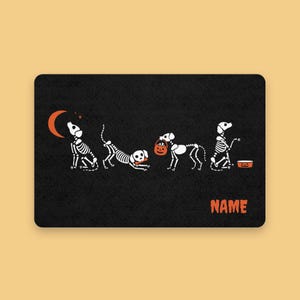 Könnte beinhalten: Schwarze rechteckige Matte mit einem Halloween-Motiv. Das Design zeigt Skeletthunde in verschiedenen Posen, einen Halbmond und das Wort "NAME" in Orange. Die Hunde sind weiß mit schwarzen Umrissen.