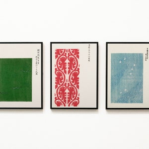 Puede incluir: Tres impresiones enmarcadas con texto japonés y diseños abstractos. La impresión de la izquierda presenta un cuadrado verde con líneas blancas. La impresión del centro presenta un patrón floral rojo y blanco. La impresión de la derecha presenta un diseño azul y blanco con puntos blancos.