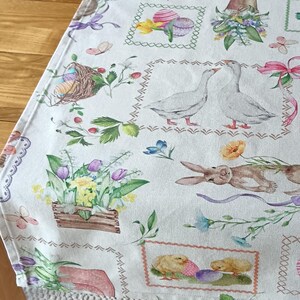 Easter table linen in cream featuring bunnies and chicks in pastel shades