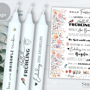 May include: Three white candles with black text and illustrations. The candles are decorated with a bee, a strawberry, and a bird. The text on the candles reads "lass uns MAIBOWLE trinken", "Hallo FRÜHLING", and "Einladung zum ANGRILLEN".