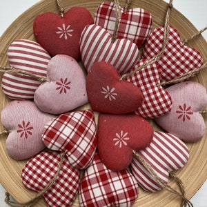 Fabric hanging hearts in red color palette made from canvas and jacquard fabric