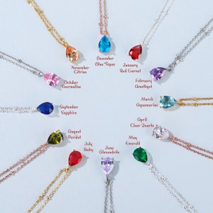 Peut inclure: Un ensemble de 12 colliers avec des pendentifs en forme de goutte de pierre de naissance. Chaque pendentif est d'une couleur différente et représente un mois différent de l'année. Les colliers sont en chaînes argent, or et or rose.