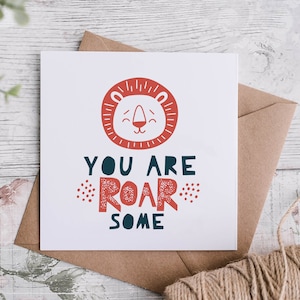 May include: A white card with a red lion face illustration and the text "You are roar some". The card is on a brown envelope with twine.
